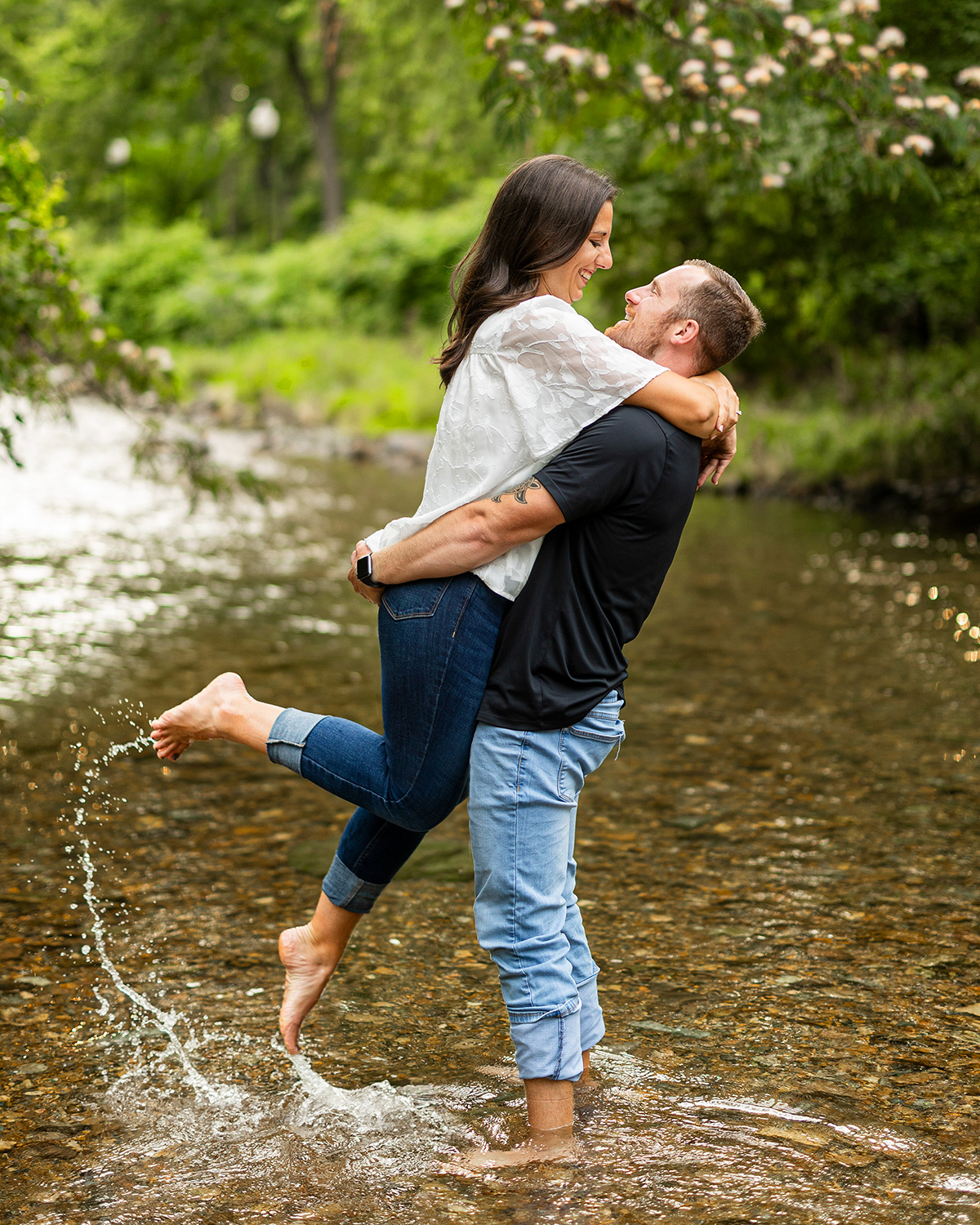 munro engagement photo in a shallow creek in the woods